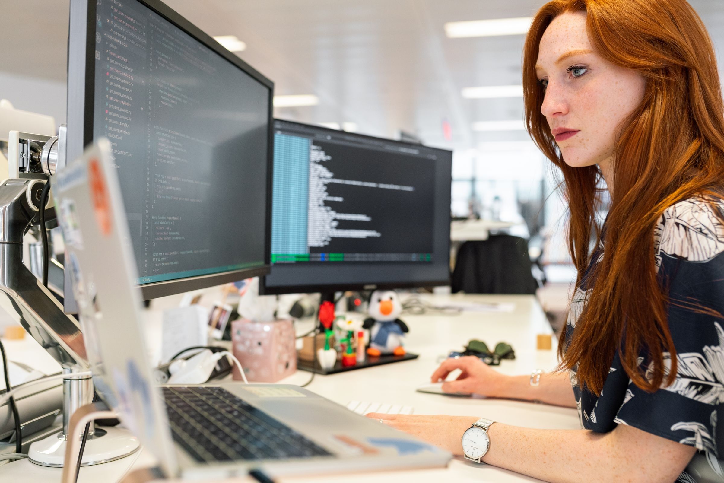A developer focused on code at her screen